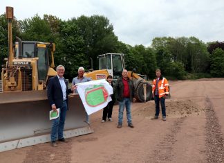 Bürgermeister Klaus Pesch, Fachplaner Georg Schlate, Michaela Maurer (Amtsleiterin) und Achim Kramer vom Amt für Kommunale Dienste sowie Bauleiter David Wasserfuhr von der Firma Strabag Sportstättenbau GmbH auf der Baustelle an der Schwarzbachstraße. Foto: Stadt Ratingen